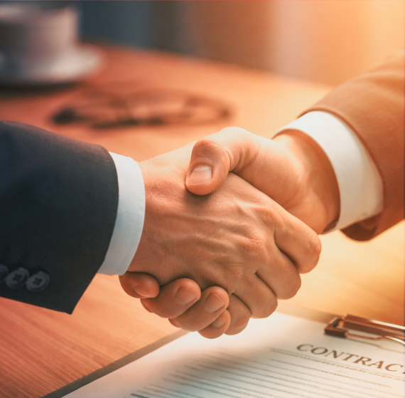 Two professionals shaking hands over a contract